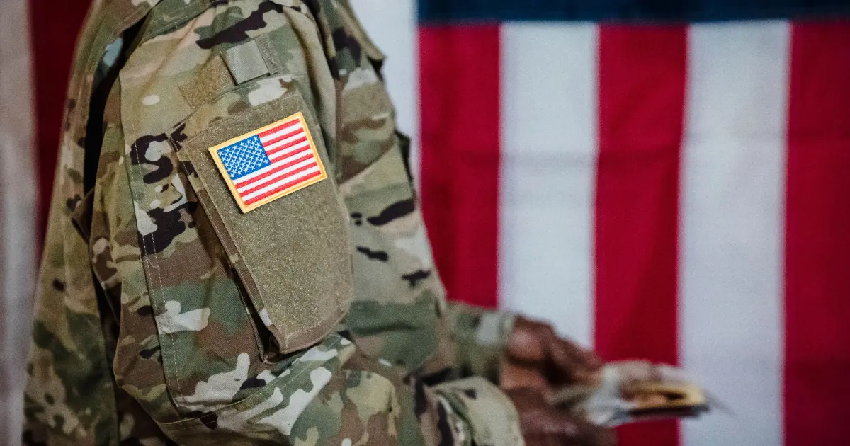 US military service member in camouflage uniform with an American flag patch, representing VA loan eligibility and Certificate of Eligibility (COE)