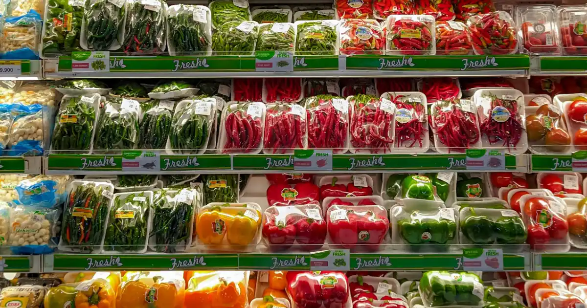 Supermarket grocery shelf filled with fresh vegetables and food items