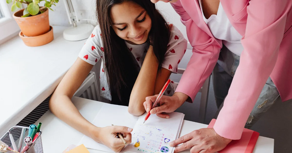A mother helping her child with paperwork at a desk, representing TANF cash assistance and family support programs for low-income families.